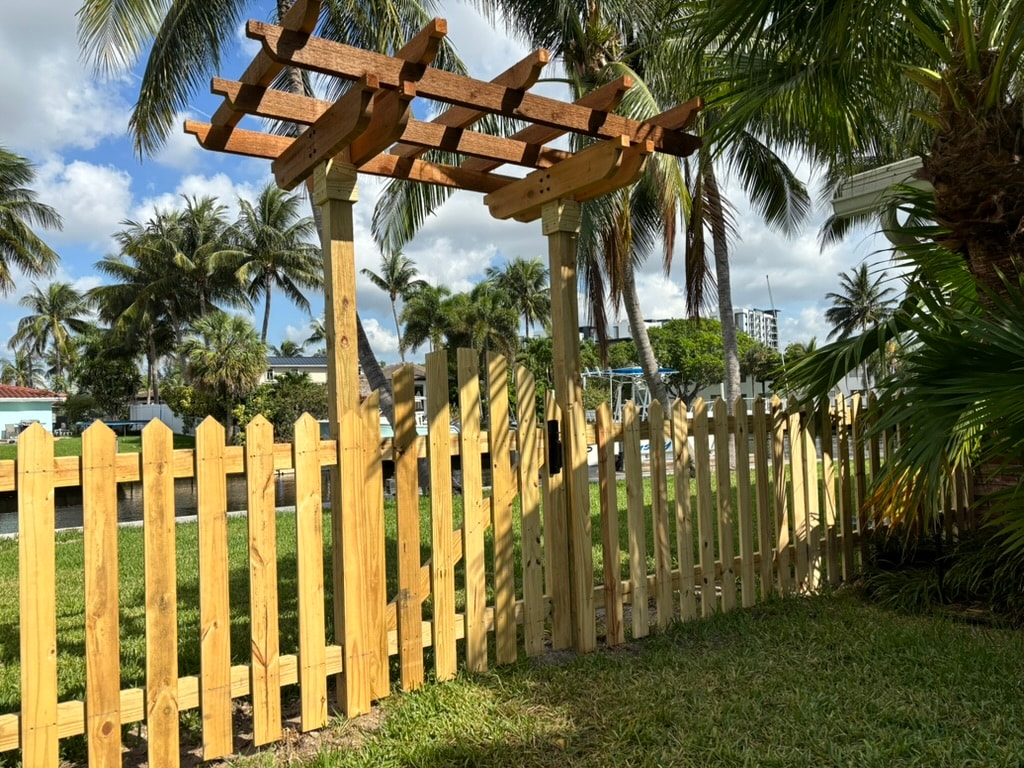 Finished pergola trellis and picket fence in tropical yard